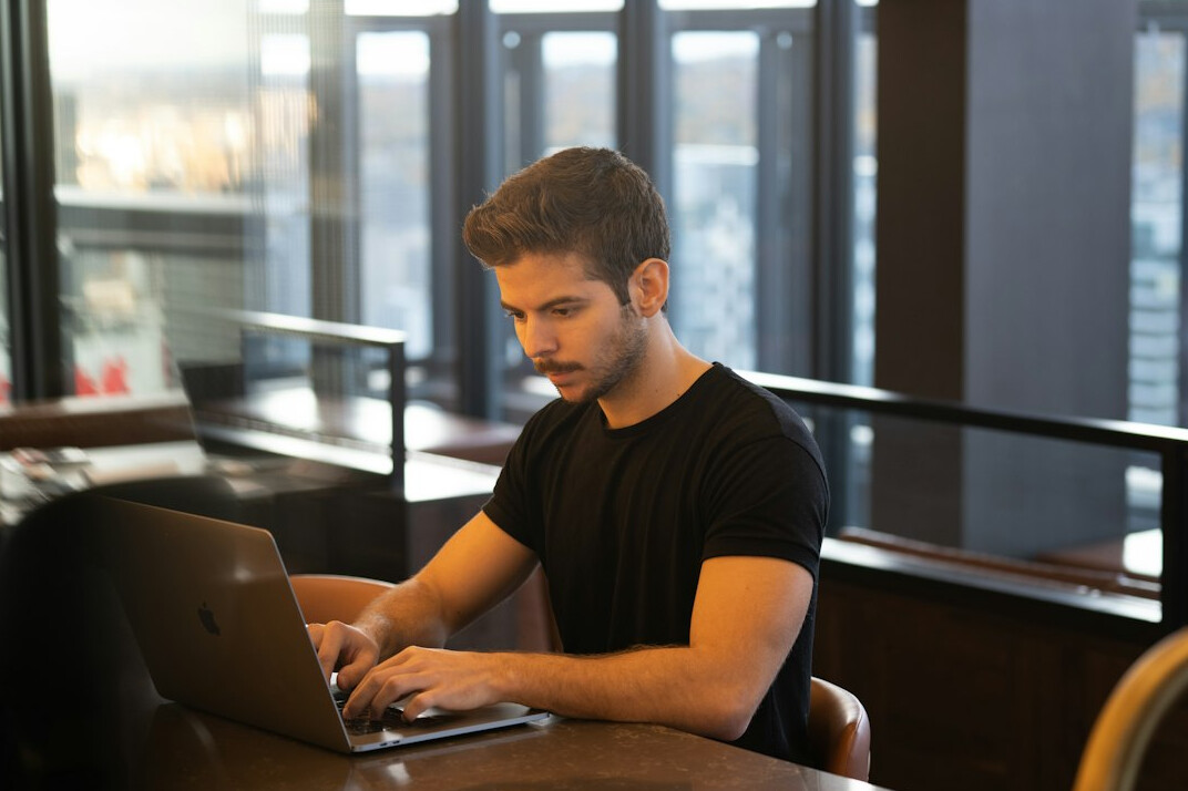 young man learning to code on laptop